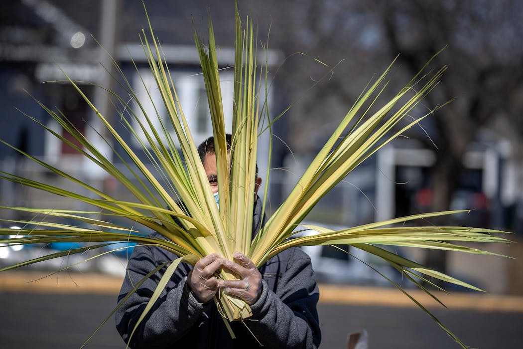 Isidro Bautista gave out palms at St. Paul's Our Lady of Guadalupe Catholic Church on Palm Sunday.