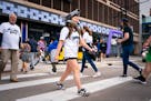 Grace Dvorak, in a Crunch the Wolf hat mask, crosses the street as she joins fans heading to the Timberwolves playoff game against the Denver Nuggets 
