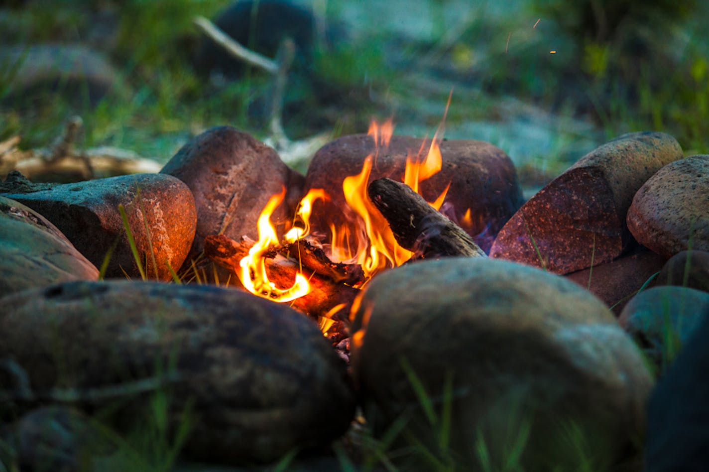 Tourist bonfire at dusk in the forest framed by stones