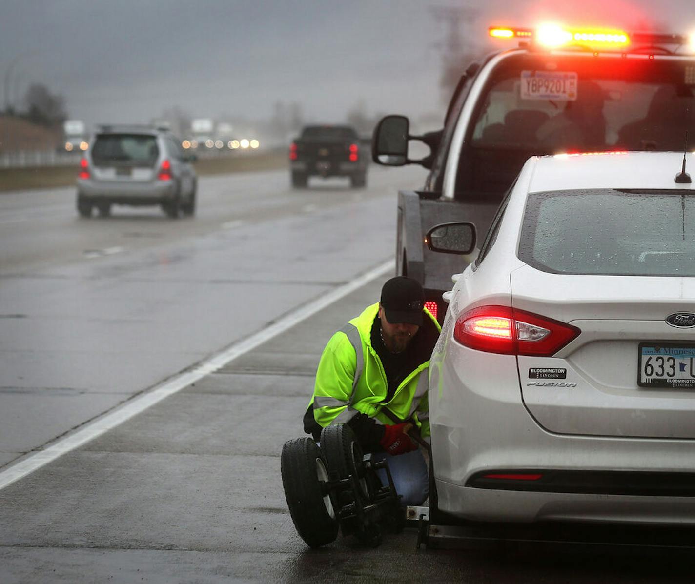 Tim Heldman, owner of Absolute Towing and Recovery in Oakdale, prepared an automobile with a flat tire for towing along I-94 near Woodbury. ] JIM GEHRZ • james.gehrz@startribune.com /Oakdale, MN / March 31, 2016 8:30 AM - BACKGROUND INFORMATION: Shrinking highway shoulders in the Metro area are proving to be a safety hazard for motorists, police, and emergency personnel and tow truck drivers. Earlier this year, a St. Paul tow truck driver leapt over a median to avoid an oncoming vehicle, only to be hit — twice — by oncoming cars. The accident highlighted the tight circumstances under which police and emergency personnel operate, most of them located near the inner Metro core. We will be waiting at Absolute Towing for a tow truck call to come in, and then go out with the driver to observe the hazards he/she faces while trying to tend to a stranded motorist. Story is about the dangers tow truck drivers, police and emergency personnel face when dealing with stranded motorists. Drivers are not paying attention, they don't slow down for them, and the shoulders themselves are often negligible or nonexistent.