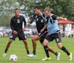 Minnesota United defender Tiago Calvano, 5, races Tyler Polak, 16, to the ball during practice at the team's facility at the National Sports Center in