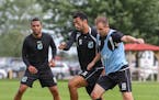 Minnesota United defender Tiago Calvano, 5, races Tyler Polak, 16, to the ball during practice at the team's facility at the National Sports Center in