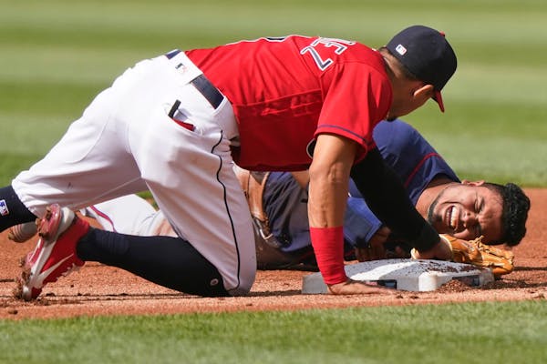 Minnesota Twins' Luis Arraez, right, reacts after trying to steal to second base in the first inning of a baseball game against the Cleveland Indians,
