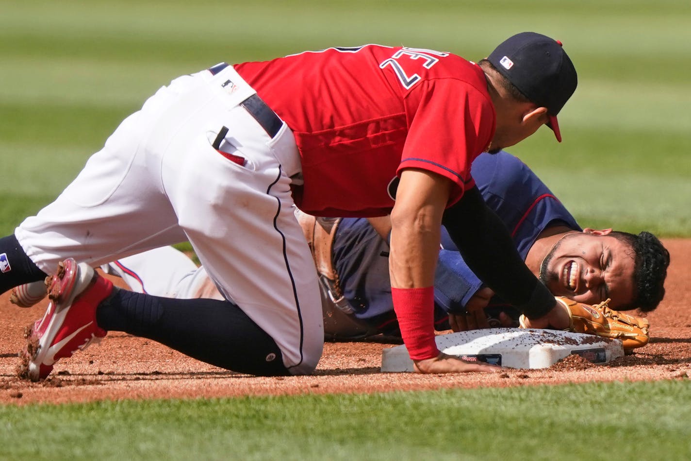 Minnesota Twins' Luis Arraez, right, reacts after trying to steal to second base in the first inning of a baseball game against the Cleveland Indians, Saturday, May 22, 2021, in Cleveland. Indians' Cesar Hernandez, left, looks on. Arraez was injured on the play. (AP Photo/Tony Dejak)