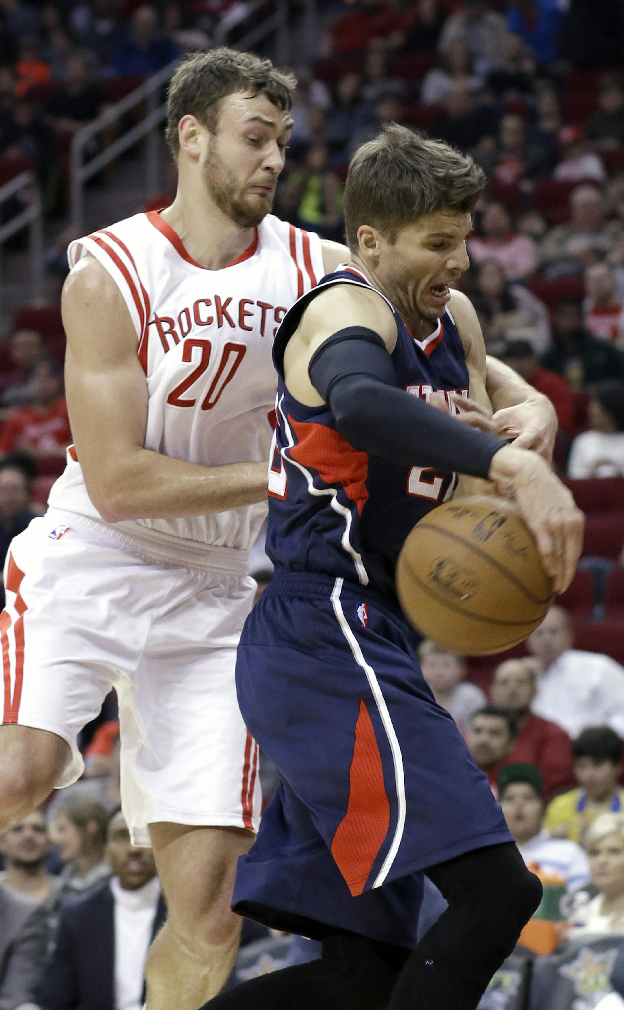Houston Rockets' Donatas Motiejunas (20) and Atlanta Hawks' Kyle Korver fight for a loose ball in the first half of an NBA basketball game Saturday, Dec. 20, 2014, in Houston. (AP Photo/Pat Sullivan)