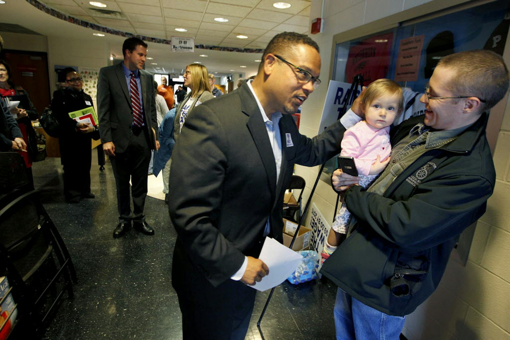 Congressman Keith Ellison was greeted by Mike Shaw and his daughter Claire Shaw, 16 months, after a roundtable discussion about raising the minimum wage at Powderhorn Recreation Center, Monday,