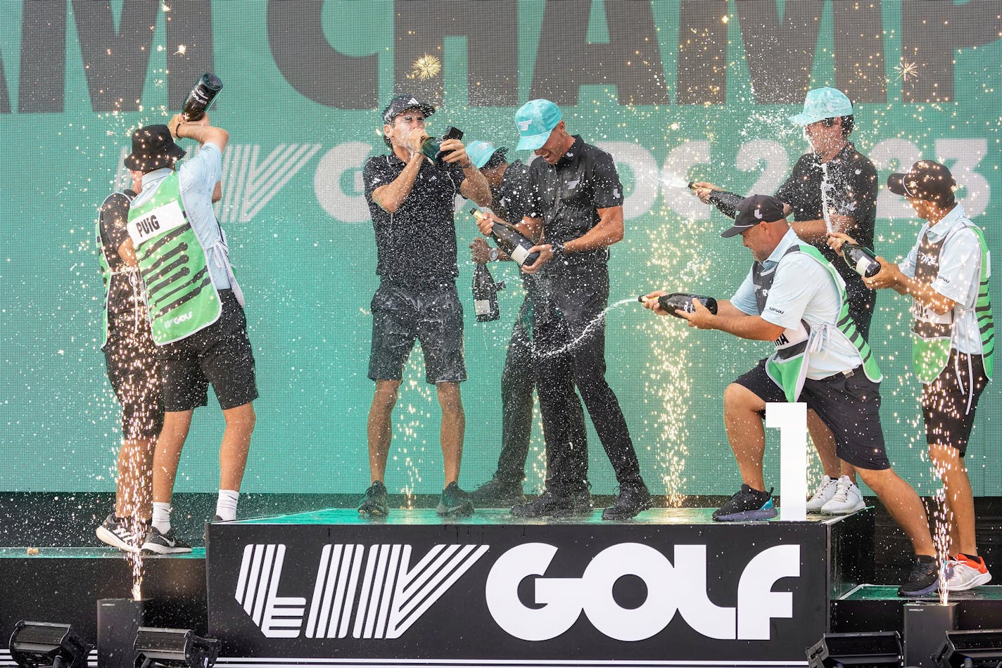 FILE - Team champions David Puig, Sebastián Muñoz, Mito Pereira, Captain Joaquín Niemann of Torque GC and their caddies celebrate on stage with the team trophy during LIV Golf DC at the Trump National Golf Club in Washington Sunday, May 28, 2023, in Sterling, Virginia. The most disruptive year in golf ended Tuesday, June 6, 2023, when the PGA Tour and European tour agreed to a merger with Saudi Arabia's golf interests, creating a commercial operation designed to unify professional golf around the world.(Photo by Chris Trotman/LIV Golf via AP, File)