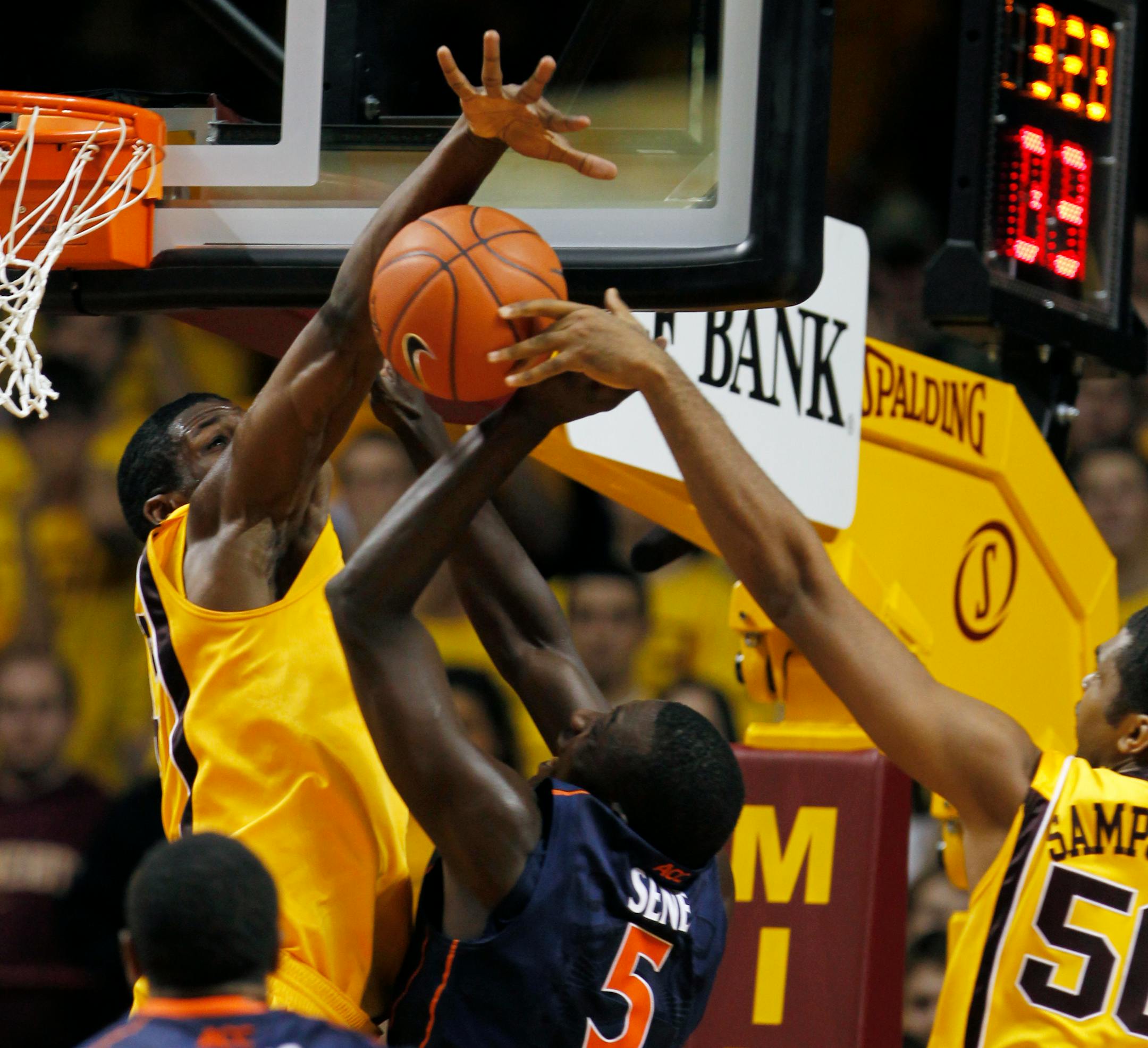 Trevor Mbakwe (32) and Ralph Sampson III (50) team up to block a shot by Virginia's Assane Sene (5) in the second half.