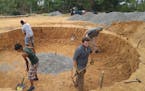 Minnesota engineers Greg Brucker and Kellen O&#xed;Brien work with local men to prepare the building site for a new water storage tank in Milla Tres, 