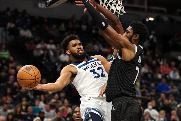Karl-Anthony Towns passes the ball while the Kings' Chimezie Metu defends in the third quarter.
