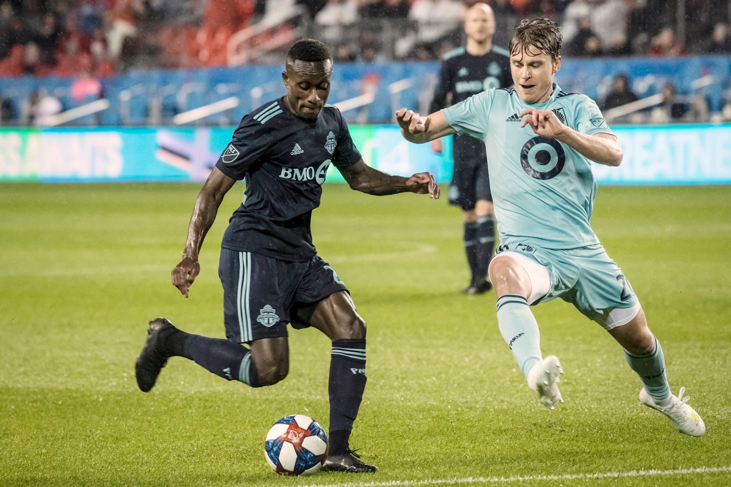 Toronto FC midfielder Richie Laryea (22) battles for the ball against Minnesota United midfielder Rasmus Schuller (20) during Friday's first-half action.