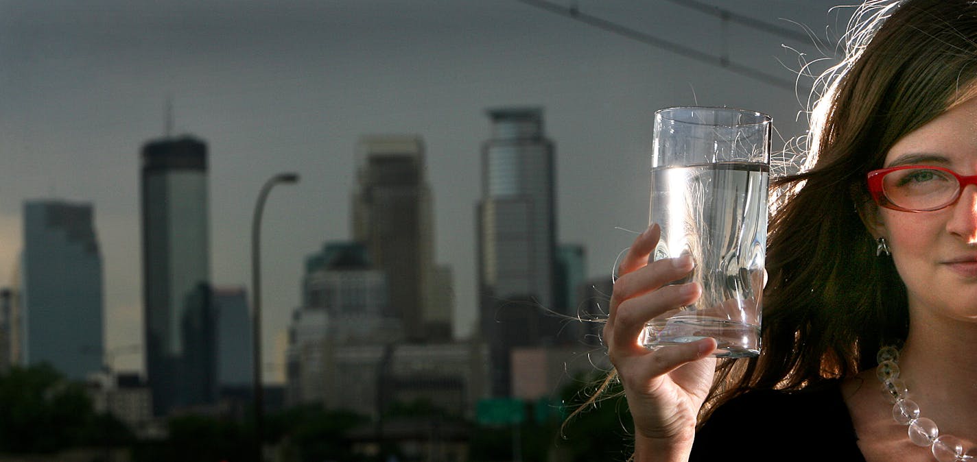 Jenna Rosener held a glass of tap water drawn from her Minneapolis home. Tap water in some city homes has been discolored and is giving off an unpleasant odor.