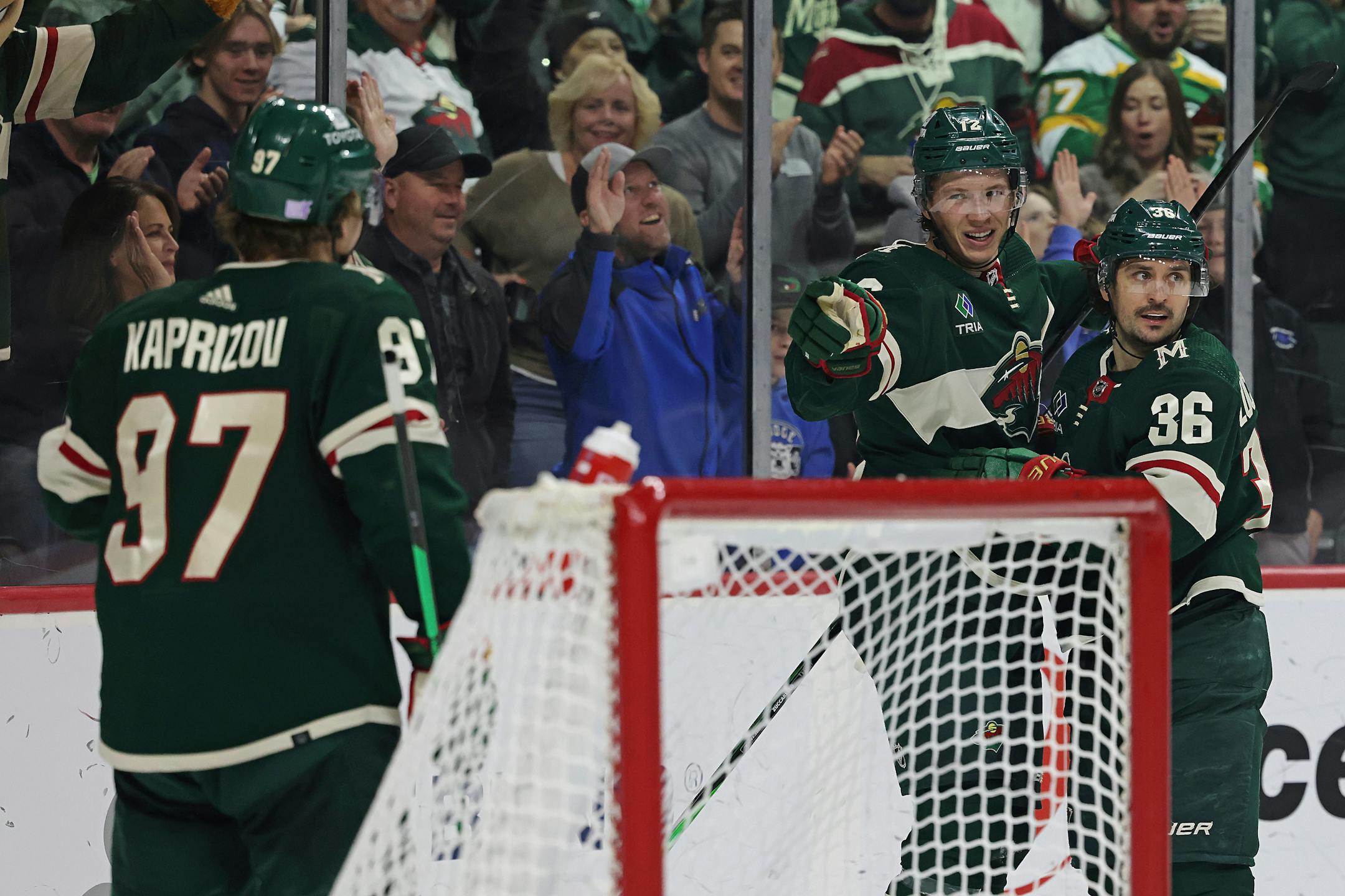 Minnesota Wild left wing Matt Boldy (12) points to left wing Kirill Kaprizov (97) in celebration after Boldy scored a goal against the Arizona Coyotes during the third period of an NHL hockey game Sunday, Nov. 27, 2022, in St. Paul, Minn. Minnesota won 4-3. (AP Photo/Stacy Bengs)