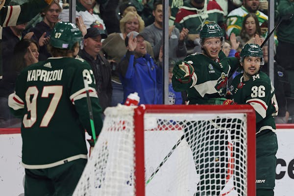 Minnesota Wild left wing Matt Boldy (12) points to left wing Kirill Kaprizov (97) in celebration after Boldy scored a goal against the Arizona Coyotes