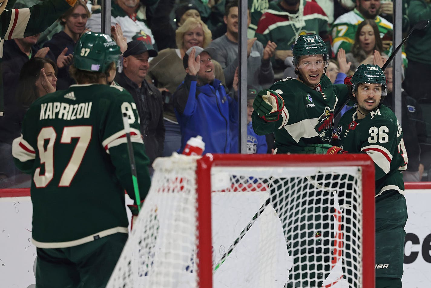 Minnesota Wild left wing Matt Boldy (12) points to left wing Kirill Kaprizov (97) in celebration after Boldy scored a goal against the Arizona Coyotes during the third period of an NHL hockey game Sunday, Nov. 27, 2022, in St. Paul, Minn. Minnesota won 4-3. (AP Photo/Stacy Bengs)