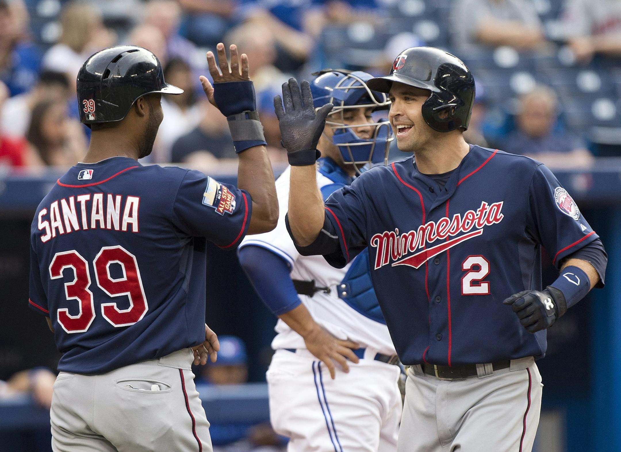 Minnesota Twins Brian Dozier (2) celebrates his two-run home run with teammate Danny Santana (39) while playing against the Toronto Blue Jays during the first inning a baseball game in Toronto on Tuesday, June 10, 2014. (AP Photo/The Canadian Press, Nathan Denette)