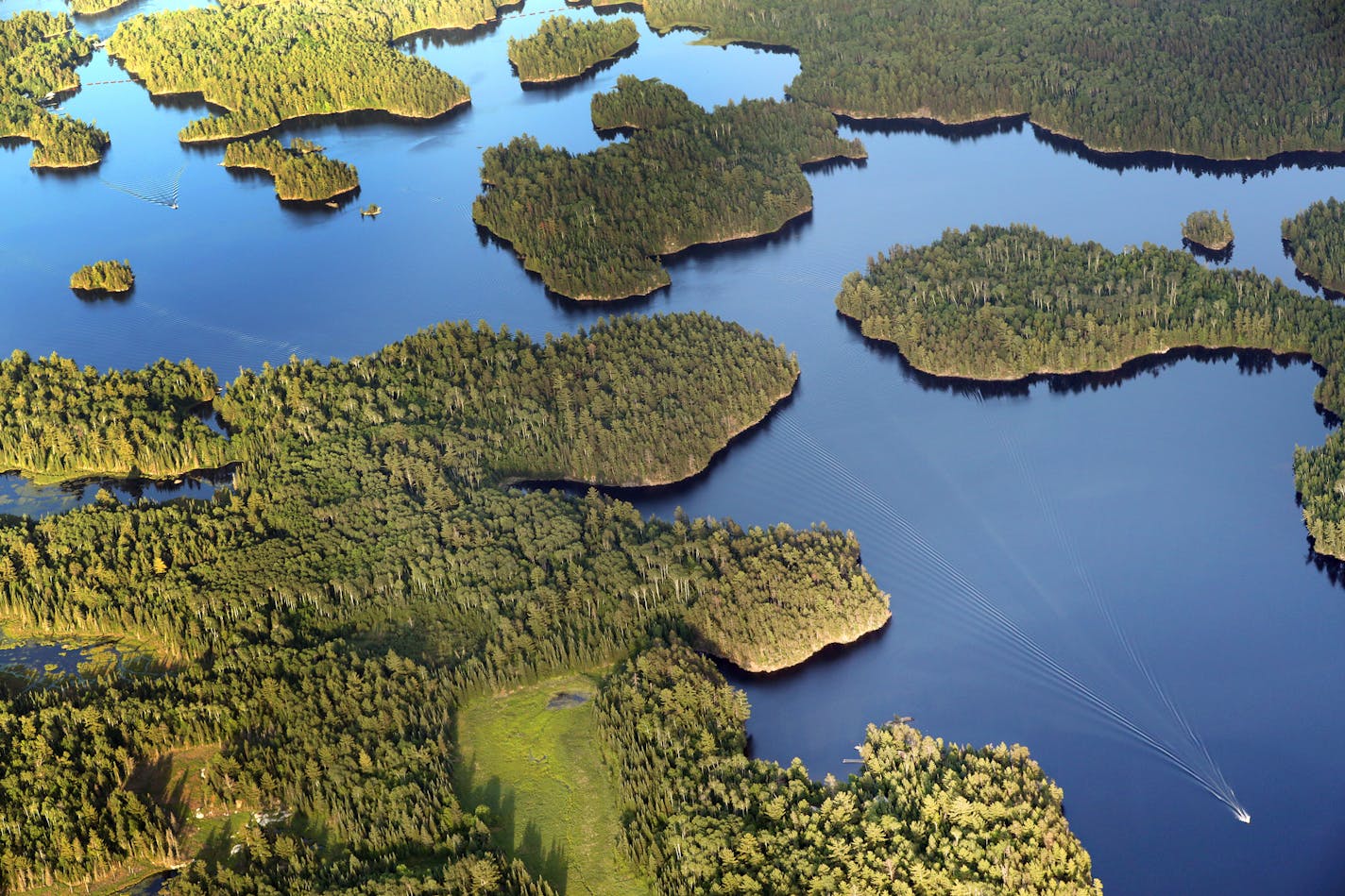 A boat navigates the waters of Namakan Lake near Kettle Falls in Minnesota's Voyageurs National Park.