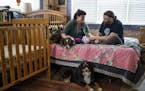 In this Dec. 5, 2018 photo, new parents Erin Petz and Matt Tyler sit with their newborn Corwyn and their two dogs in Grand Marais, Minn. The hospital 