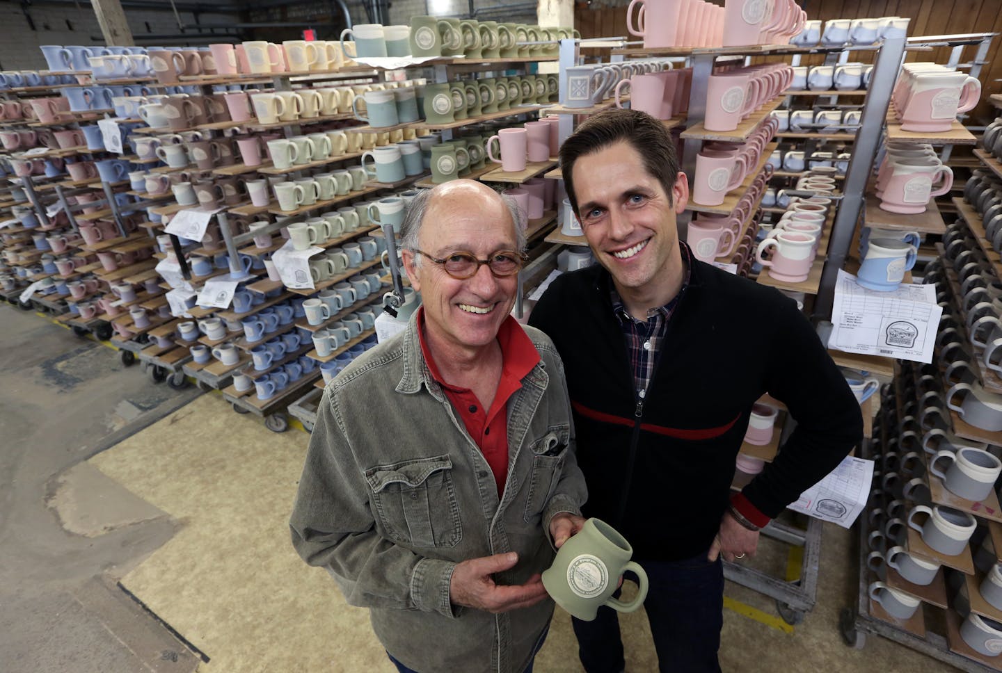 (left to right) Peter Deneen and son, Niles Deneen, photographed 4/30/14, with thousands of cups and mugs awaiting to be fired. Profile on Deneen Pottery, a small St. Paul company that makes custom stoneware and coffee mugs the old-fashioned way, by tossing a lump of clay on a potter's wheel. The company is growing by leaps and bounds, doubling its number of employees to more than 50 over the last couple of years. They even have a dog wandering the factory and shop.] Bruce Bisping/Star Tribune b