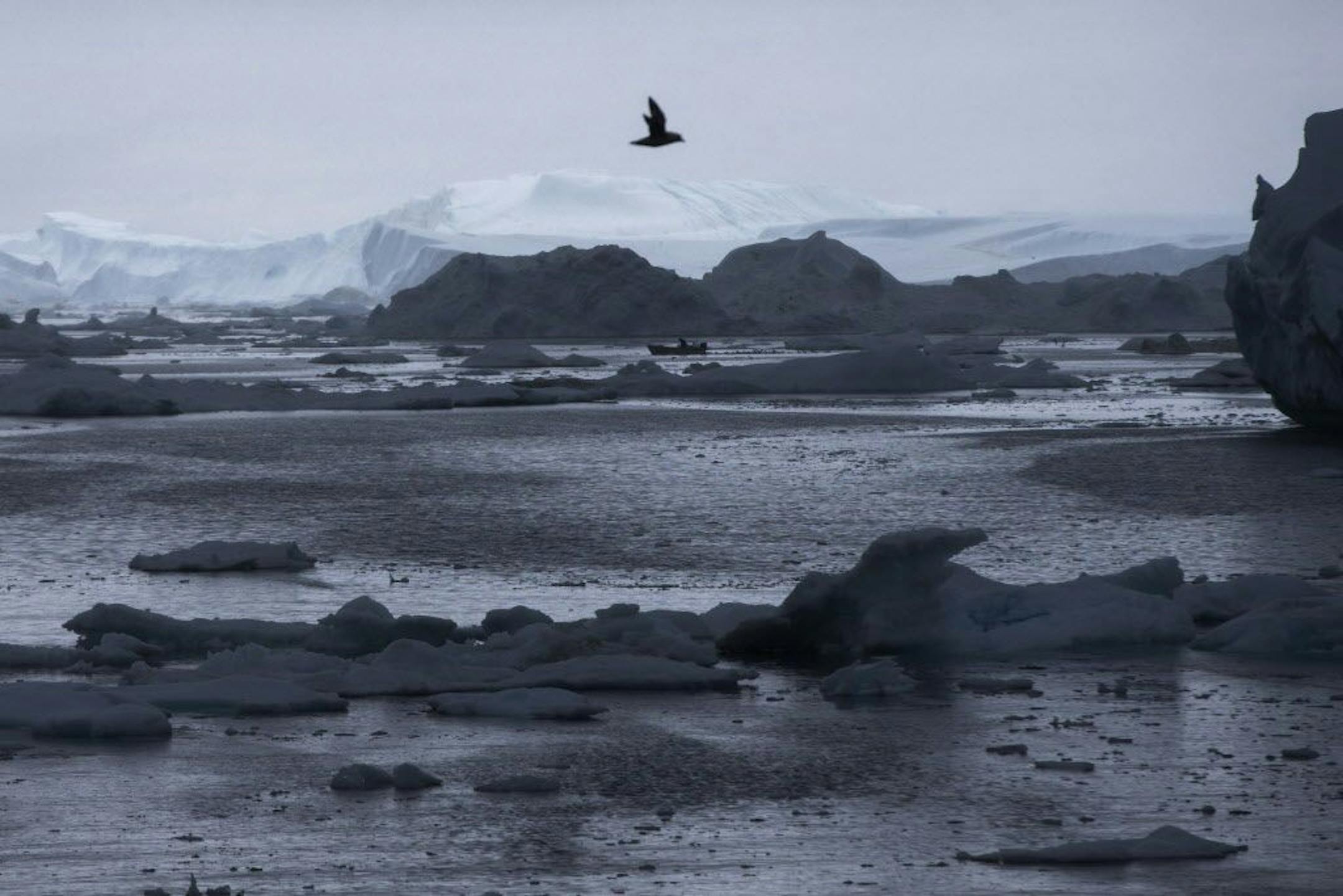 FILE - In this June 17, 2016 file-pool photo, a fisherman drives a boat during Secretary of State John Kerry's tour of the Jakobshavn Glacier and the Ilulissat Icefjord, located near the Arctic Circle in Ilulissat, Greenland. A new federal report says warming at the top of the world went into overdrive, happening twice as fast as the rest of the globe, and extending unnatural heating into fall and winter. In its annual Arctic Report Card, the National Oceanic and Atmospheric Administration Tuesd