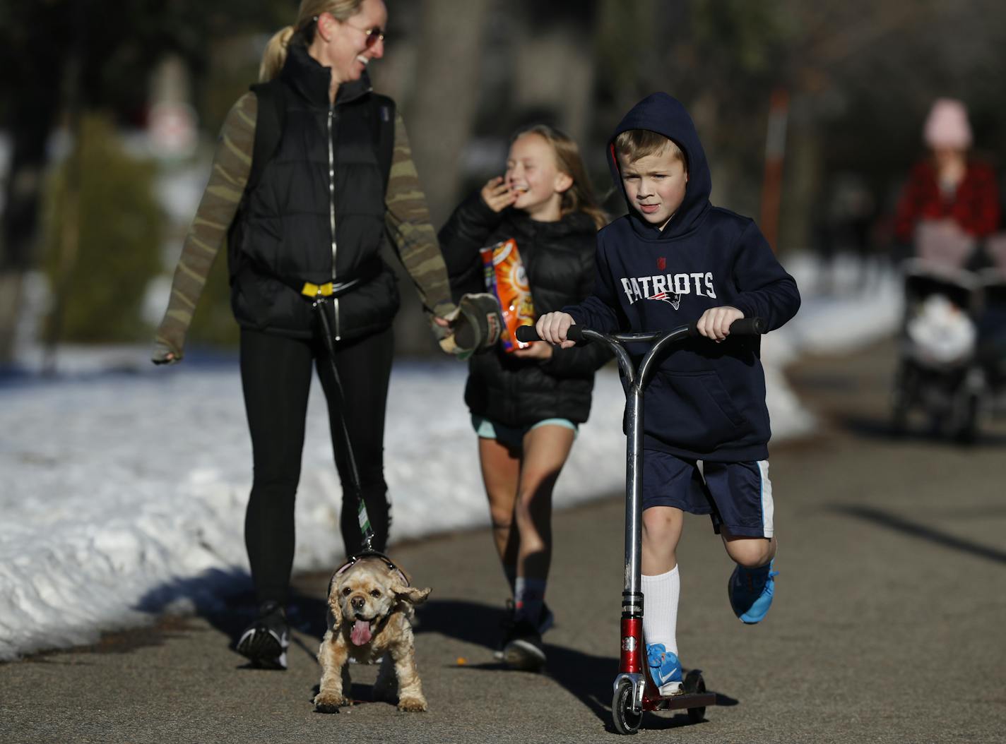 A day made for being outdoors: Laura Truett walked Winnie while her daughter Piper, 9, and son Hunter, 7, circled Lake of the Isles in shorts Sunday.