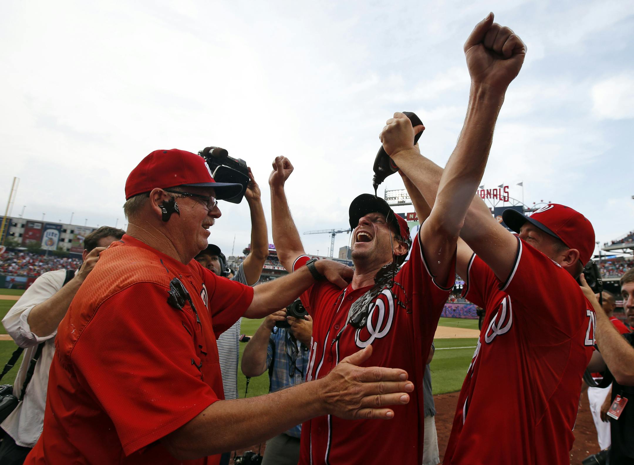 Washington Nationals' Jordan Zimmermann, right, douses starting pitcher Max Scherzer, center, with chocolate syrup as Scherzer celebrates with pitching coach Steve McCatty, left, after Scherzer's no-hitter baseball game against the Pittsburgh Pirates at Nationals Park, Saturday, June 20, 2015, in Washington. The Nationals won 6-0. (AP Photo/Alex Brandon) ORG XMIT: NAT118