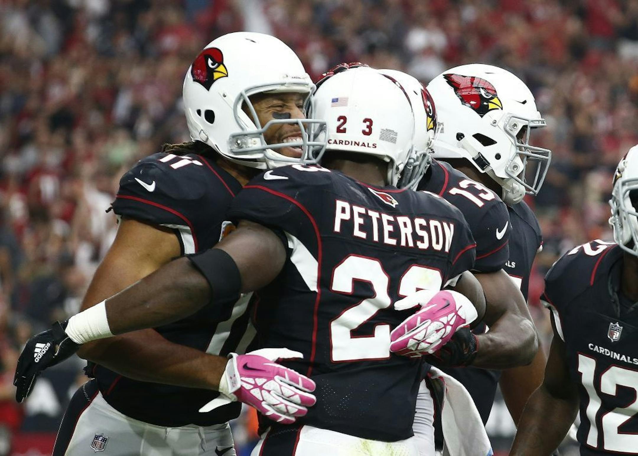 Cardinals wide receiver Larry Fitzgerald Jr. (11) celebrated a touchdown against Tampa Bay by his new teammate, running back Adrian Peterson, during the first half Sunday in Glendale, Ariz.