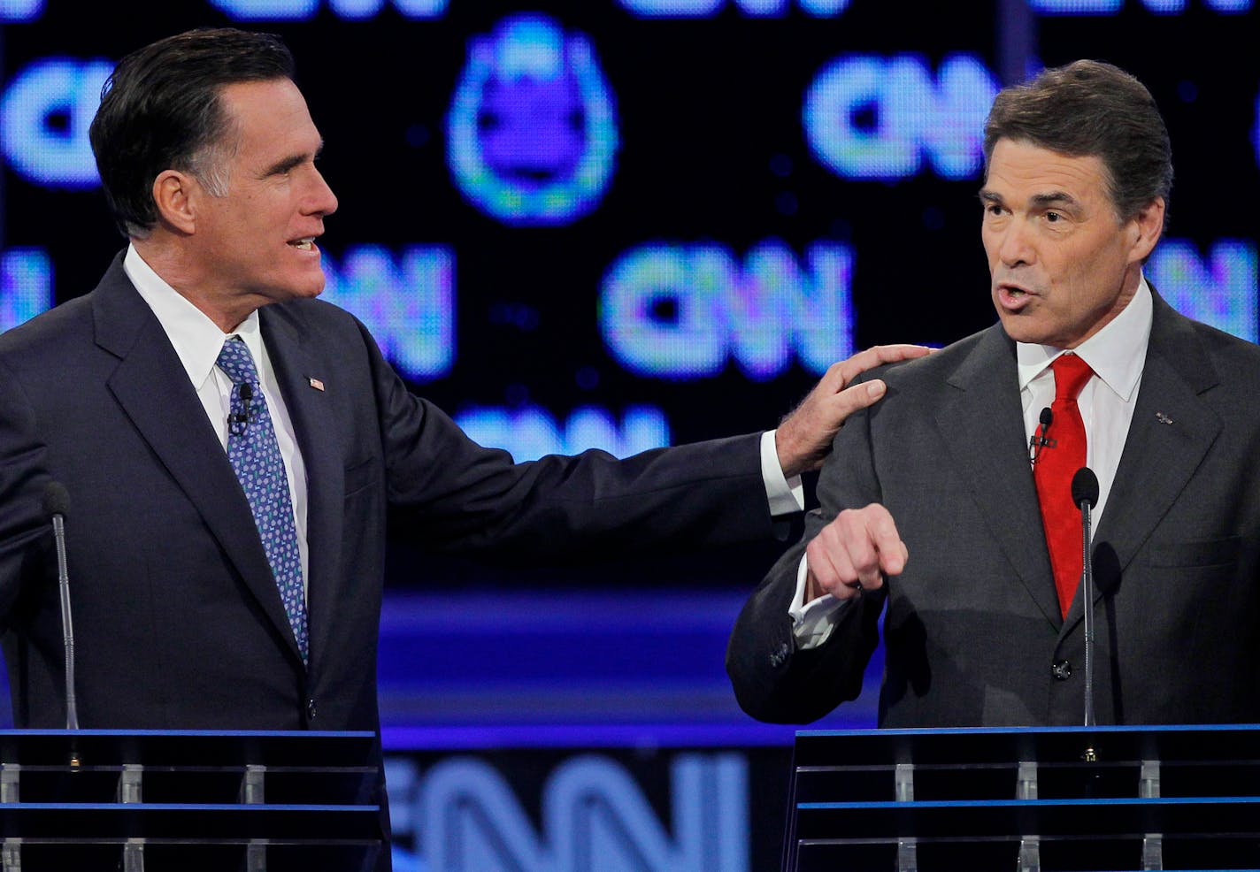 Republican presidential candidate former Massachusetts Gov. Mitt Romney, left, and Texas Gov. Rick Perry speak during a Republican presidential debate Tuesday, Oct. 18, 2011, in Las Vegas. (AP Photo/Chris Carlson)