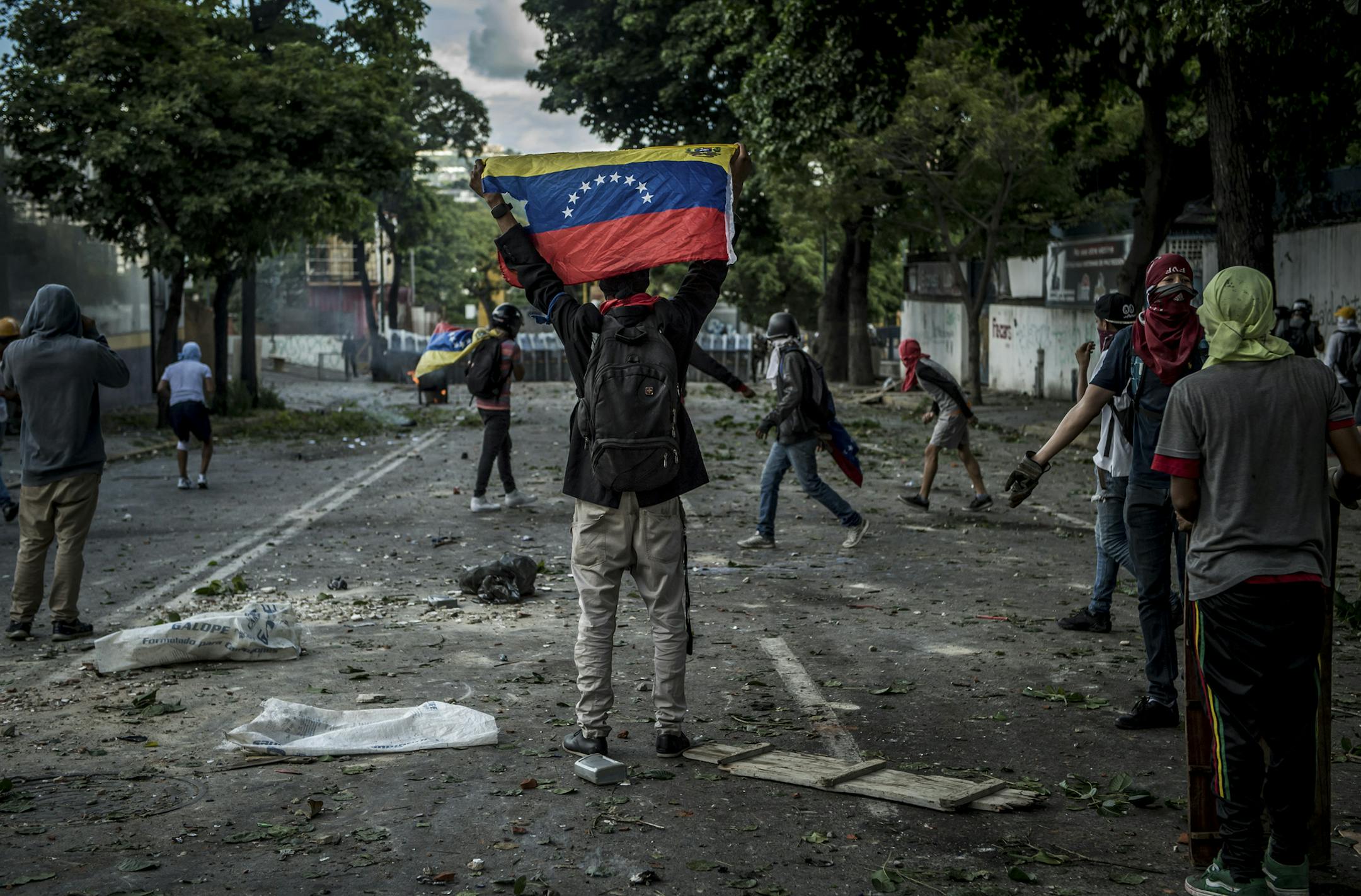 A protester holds up the Venezuelan flag during clashes with soldiers at an anti-government demonstration to demand that the National Constituent Assembly election be cancelled, in Caracas, Venezuela, July 26, 2017. President Nicolás Maduro’s plan to create a new assembly is expected to give leftists virtually unlimited authority. (Meridith Kohut/The New York Times)