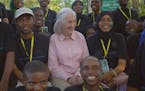 Dr. Jane Goodall posing with members of Roots & Shoots, a program of the Jane Goodall Institute. National Geographic's JANE GOODALL: THE HOPE picks up