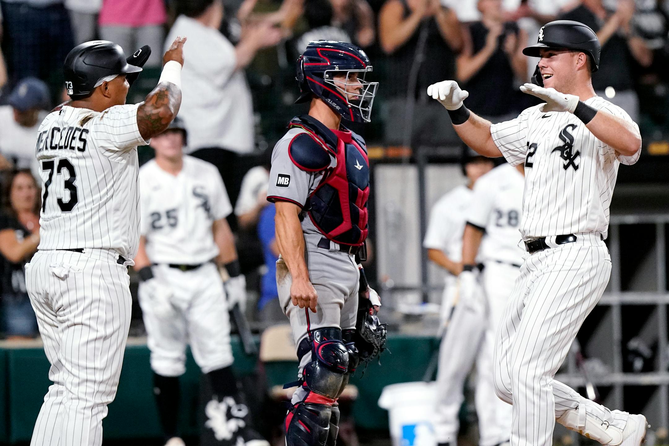 Chicago White Sox's Gavin Sheets, right, celebrates with Yermin Mercedes, left, after hitting a two-run home run as Minnesota Twins catcher Ben Rortvedt looks to the field during the fifth inning of a baseball game in Chicago, Wednesday, June 30, 2021. (AP Photo/Nam Y. Huh)