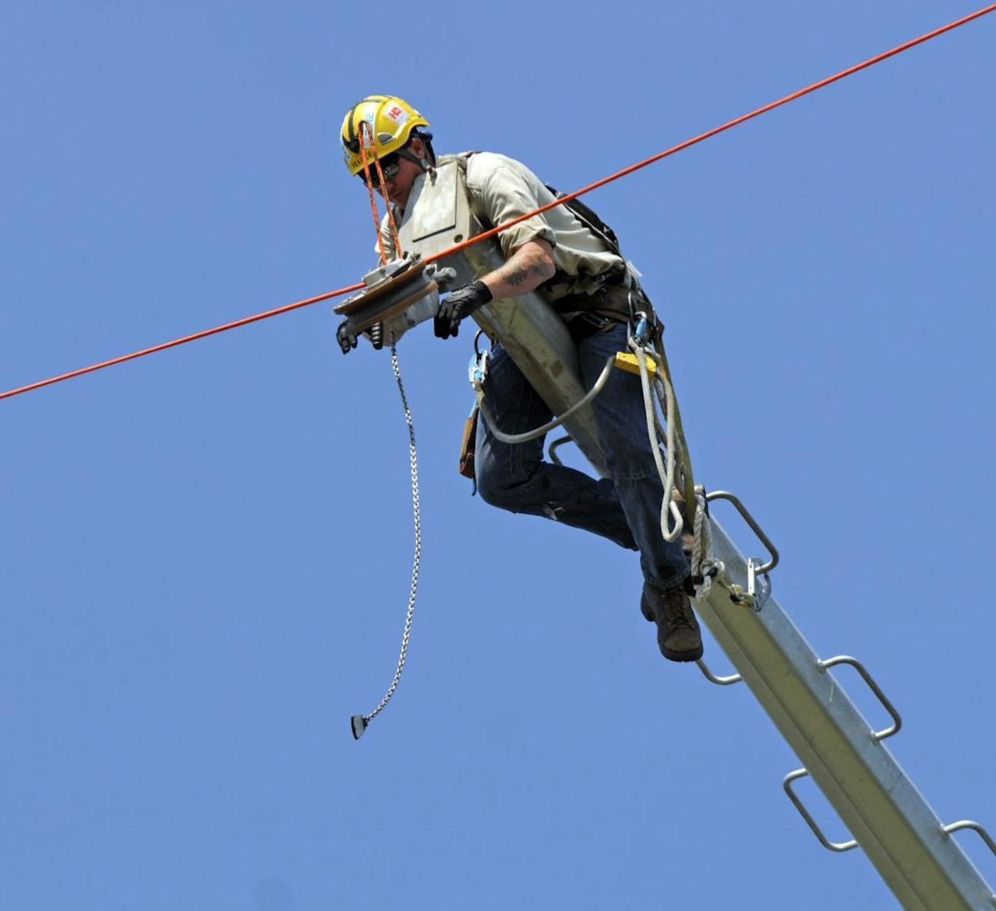 This lineman was delivered to the 150 tower by helicopter.Xcel Energy is installing a new power line along I-94 between Monticello and St. Cloud.On Thursday August 25 2011 in Clearwater, Minn. Harnessed workers hanging from helicopters weree doing some of the high-wire work, which consists of stringing transmission conductor lines and other hardware from pole to pole. It's part of the first major upgrade of high voltage power lines in the state in 30 years.