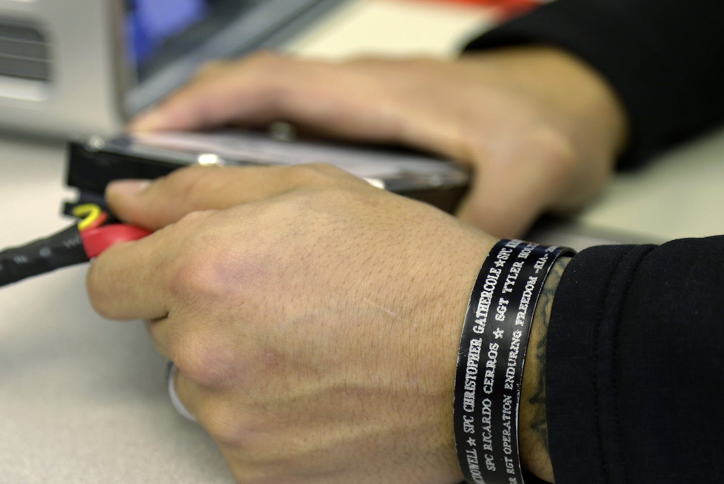 Zepeda wears a metal bracelet bearing the names of friends who died while serving with him during his nine tours of duty.