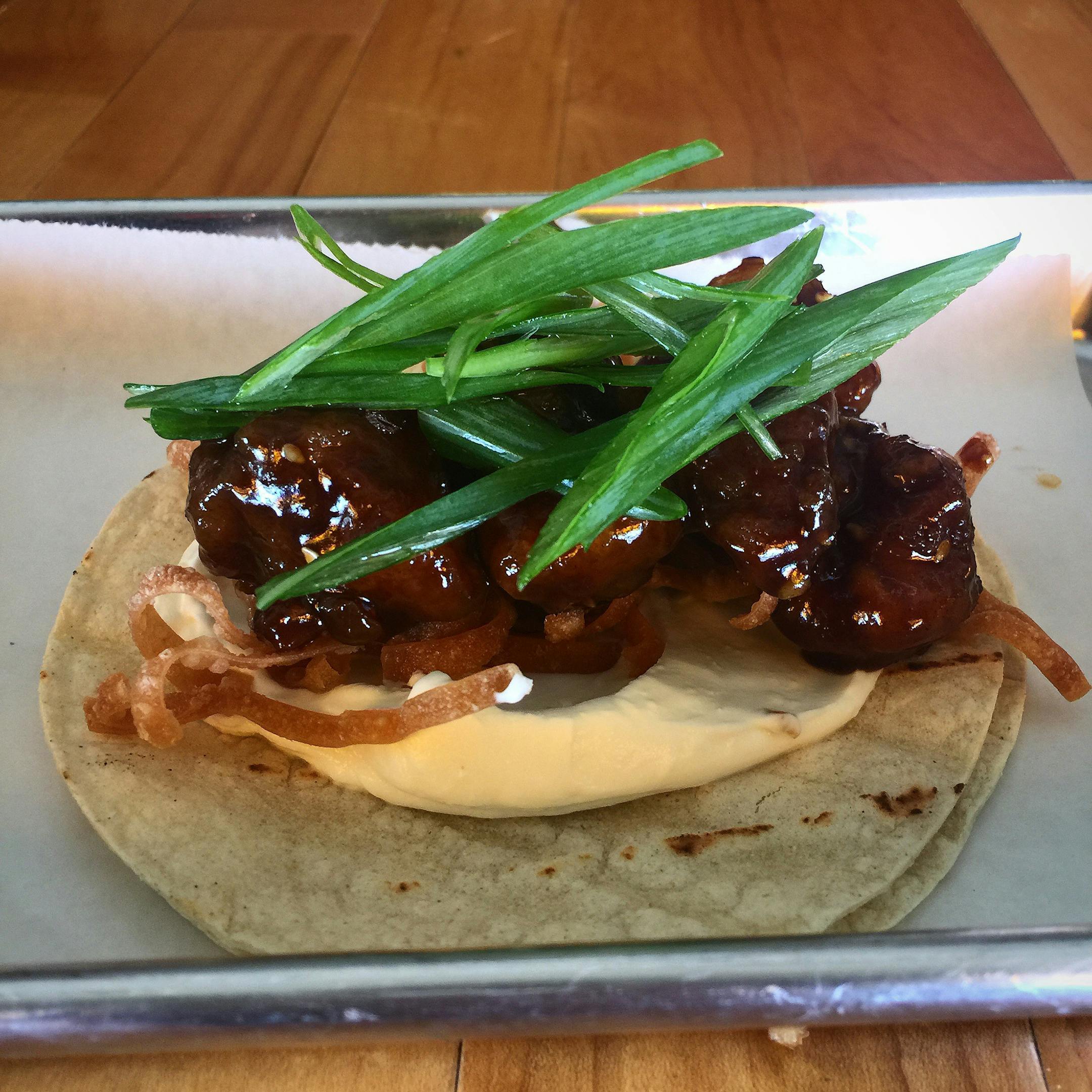 General Tso Chicken Taco: Battered and deep-fried chicken tossed in a sauce of ginger, garlic, soy sauce and Asian spices, with seasoned cream cheese and topped with wonton crisps and green onion, served on a flour tortilla. At Midtown Global Market's Taco Cat, located in the Taste of the Midtown Global Market booth at the International Bazaar, east wall. (Available Aug. 23-28 only)