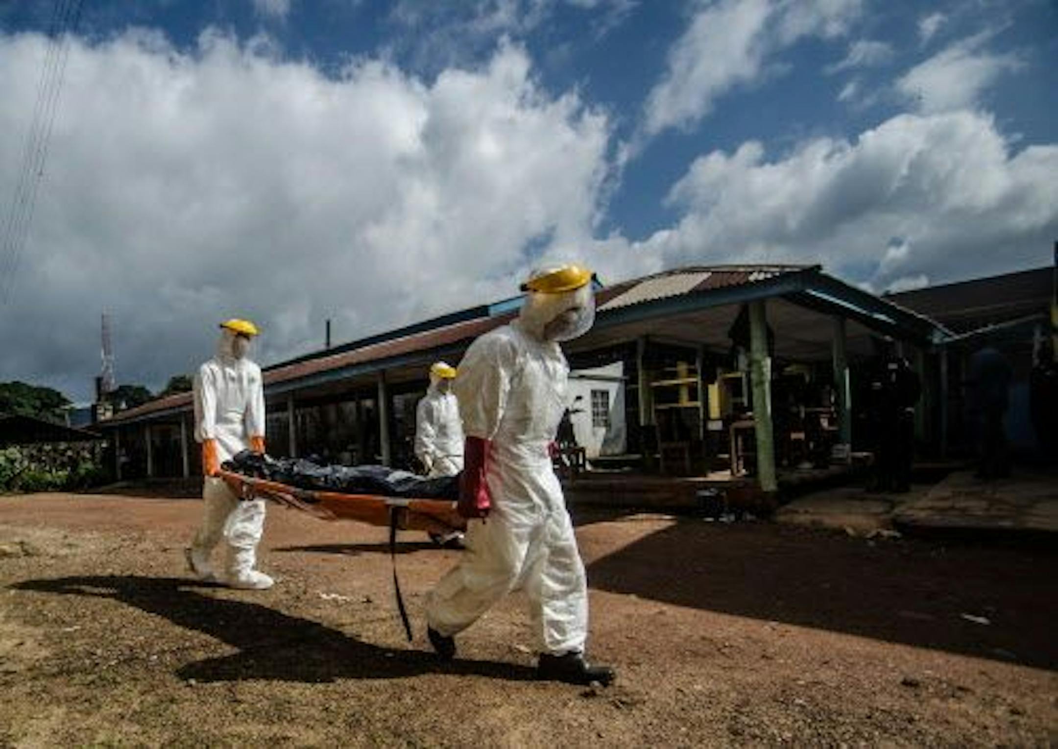 Health workers carry the body of an Ebola victim to the morgue at the hospital in Kenema, Sierra Leone, Thursday, Aug. 7, 2014.
