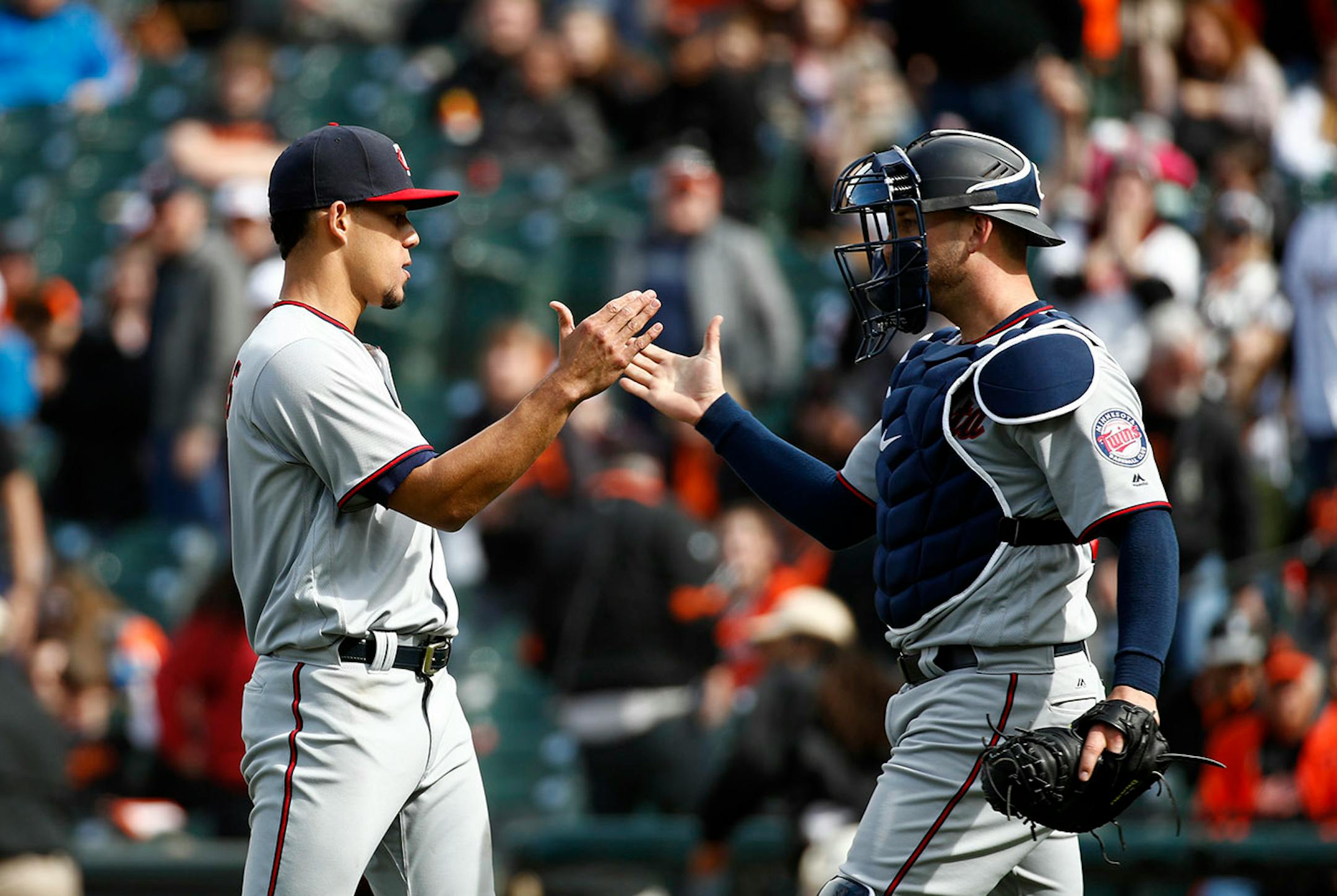 Minnesota Twins starting pitcher Jose Berrios, left, and catcher Mitch Garver high-five after closing out a baseball game against the Baltimore Orioles, Sunday, April 1, 2018, in Baltimore. Berrios pitched a complete game and Minnesota won 7-0.