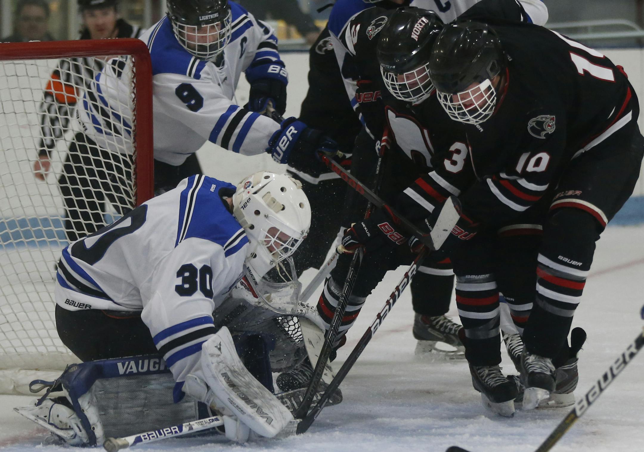 In a boy's hockey game between Eastview H.S.and Lakeville North, goalie Zach Driscoll(30) and John Snodgrass(9) defend against a rush of attackers including Jack Poehling(3) and Blake Rutt(10).]richard tsong-taatarii/rtsong-taatarii@startribune.com
