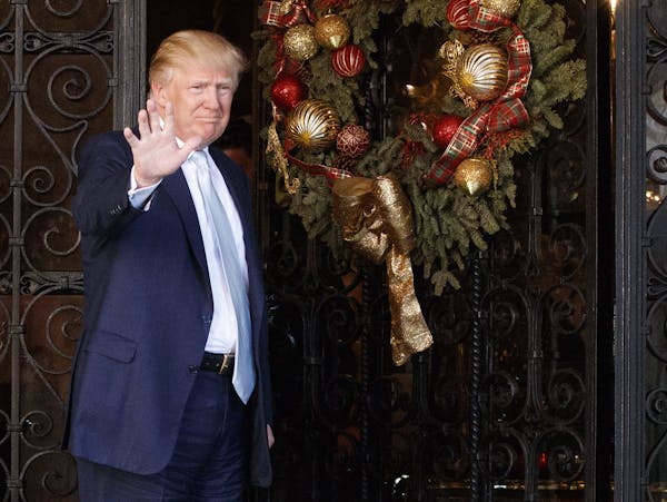 President-elect Donald Trump stands at the entrance of Mar-a-Lago and waves to reporters after meeting with Carlyle Group co-founder and co-CEO David 