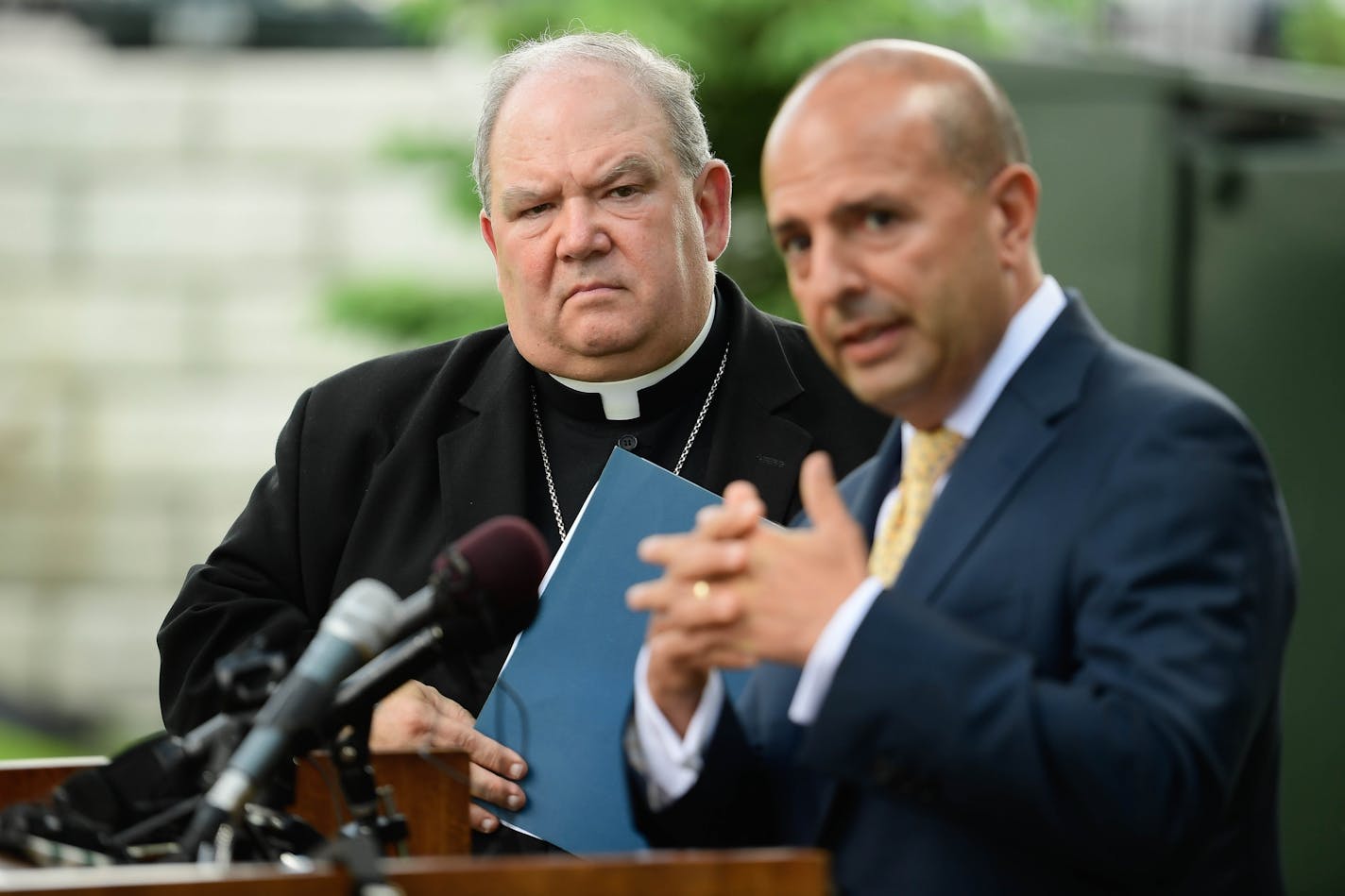 Archbishop Bernard Hebda listened as Thomas J. Abood, chair of the Archdiocesan Finance Council and Reorganization Task Force, spoke to the media Thursday about the settlement reached with survivors of clergy abuse.