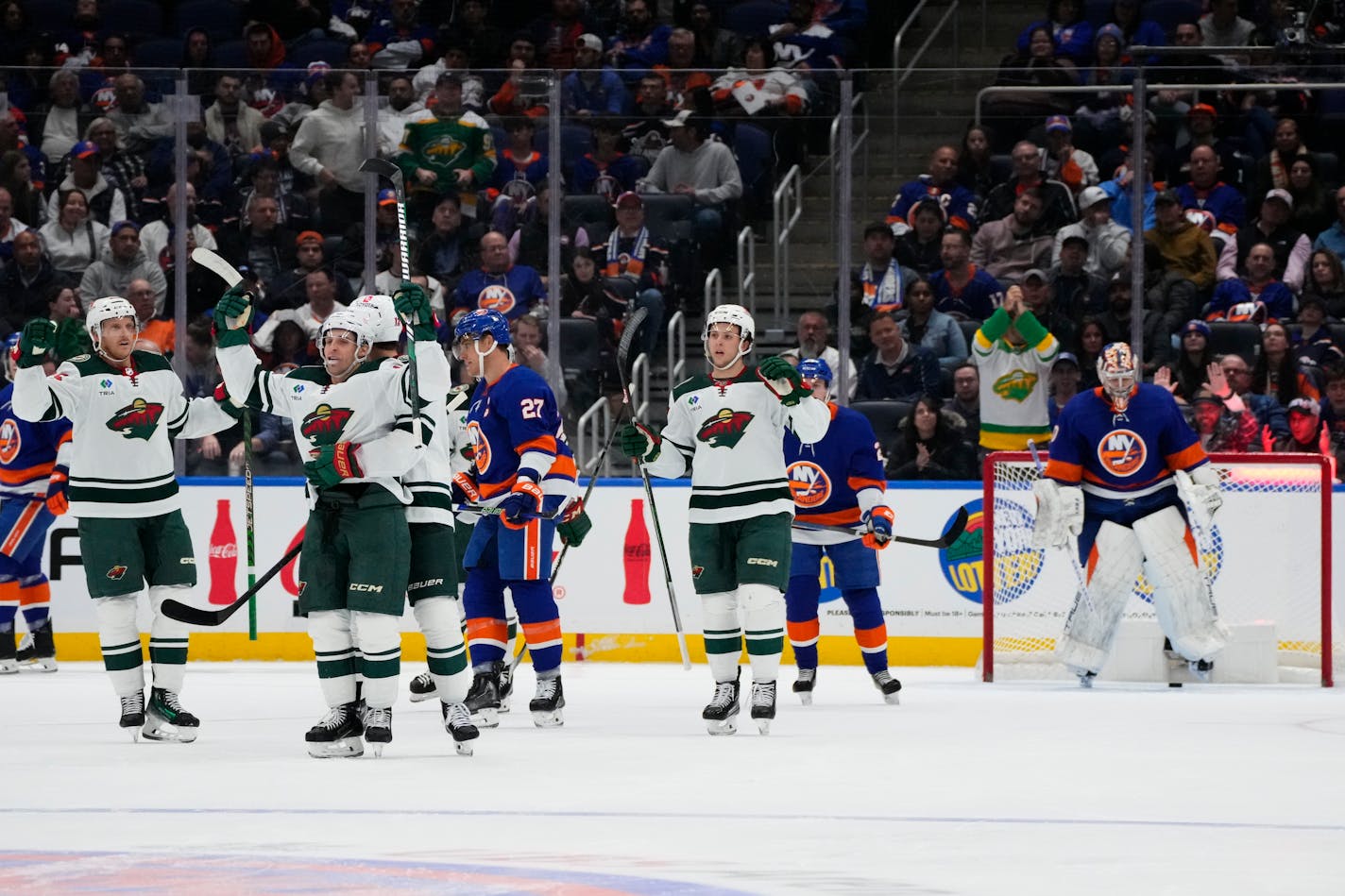 Minnesota Wild's Vinni Lettieri, second from left, celebrates with teammates after scoring a goal as New York Islanders goaltender Semyon Varlamov, right, reacts during the second period of an NHL hockey game Tuesday, Nov. 7, 2023, in Elmont, N.Y. (AP Photo/Frank Franklin II)