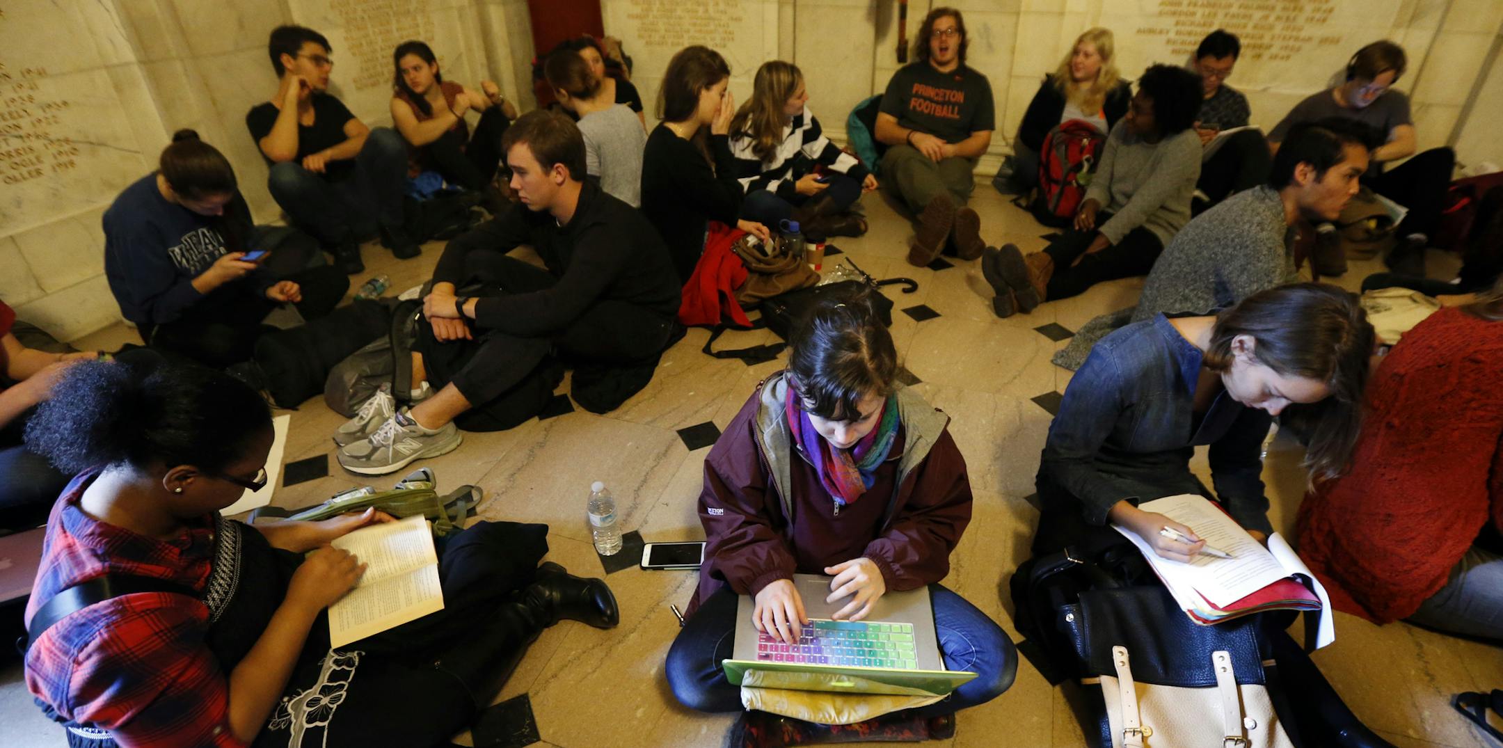 Students gather inside Nassau Hall during a sit-in, Thursday, Nov. 19, 2015, in Princeton, N.J. The protesters from a group called the Black Justice League, who staged a sit-in inside university President Christopher Eisgruber's office on Tuesday, demand the school remove the name of former school president and U.S. President Woodrow Wilson from programs and buildings over what they said was his racist legacy. (AP Photo/Julio Cortez)