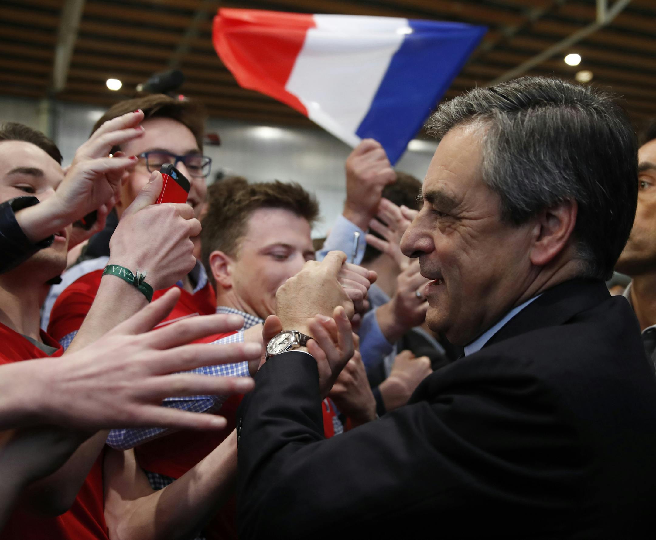 Francois Fillon, right, former French Prime Minister, member of the Republicans political party and 2017 French presidential election candidate of the French centre-right, is greeted by supporters as he arrives to attend a campaign rally in Lille, France, Tuesday, April 18, 2017. (Christian Hartmann/Pool photo via AP)