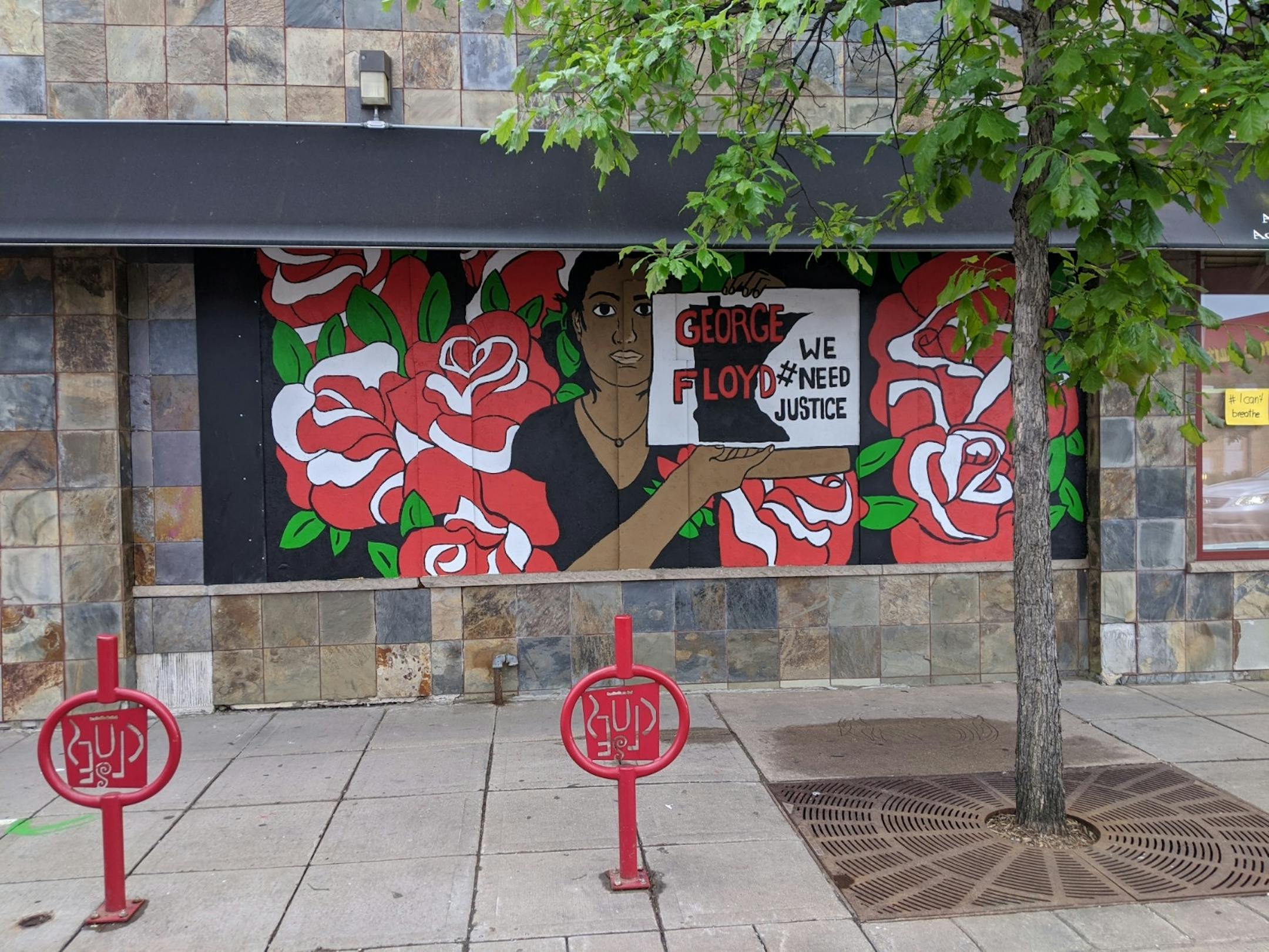 A mural of red flowers and demands for justice covers the windows of Premier Health Chiropractors of South Minneapolis (1813 E Lake St.).