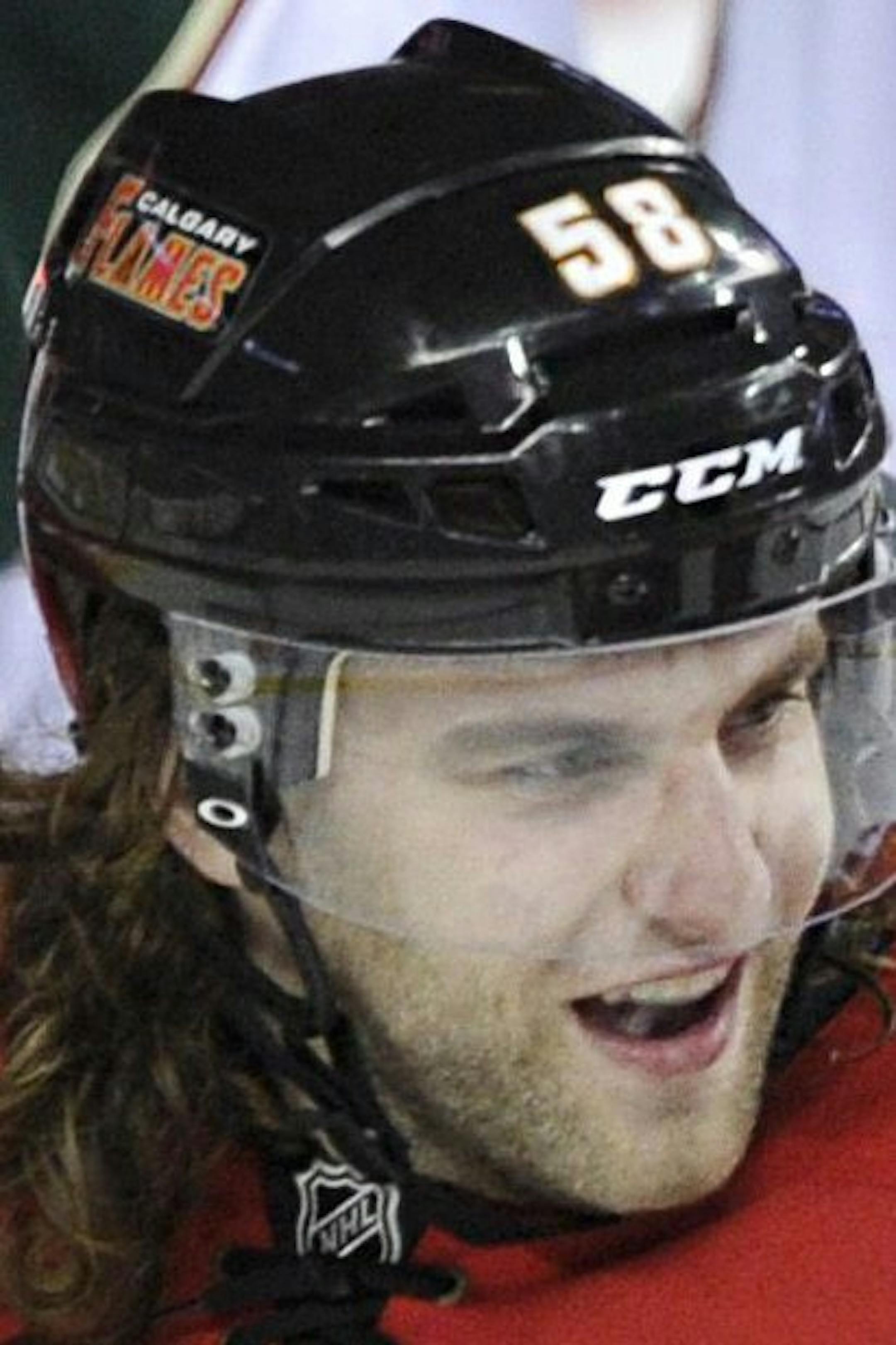 Calgary Flames' Ben Hanowski, center, celebrates his first NHL goal with Curtis Glencross, right, and Mikael Backlund, from Sweden, during the third period of an NHL hockey game against the Minnesota Wilde in Calgary, Alberta, Monday, April 15, 2013. (AP Photo/The Canadian Press, Larry MacDougal) ORG XMIT: LMD109