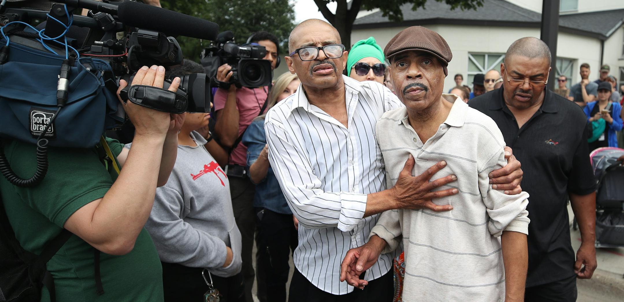Manuel Moore brother of (Thurman Blevins) left escorted his father Thurman Moore to there car after speaking to members of the north side community during a protest and rally at the 4th precinct. Manuel spoke about his brother and asked for a peaceful protest in front of the police station on Plymouth Avenue in response to the shooting death of Thurman Blevins by Minneapolis Police Sunday June 24, 2018 in Minneapolis, MN. ] JERRY HOLT ï jerry.holt@startribune.com