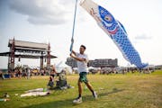 A festival goer ran around Bayfront Festival Park with fish wind streamers at the Water is Life Festival on Wednesday.