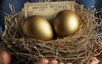 A senior male holds a nest that contains two golden eggs and a blank social security card. He holds the nest close to his chest in front of a blue swe