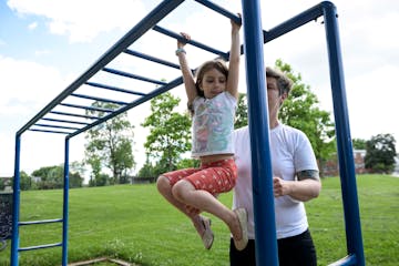 Iverson Otterson, 6, climbed across monkey bars with the help of her mother, Ericka, at Powderhorn Park in June 2020. 