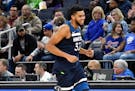 Minnesota Timberwolves' Karl-Anthony Towns smiles on his way to the bench as he is relieved late in the second half of an NBA basketball game against 