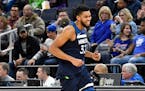 Minnesota Timberwolves' Karl-Anthony Towns smiles on his way to the bench as he is relieved late in the second half of an NBA basketball game against 